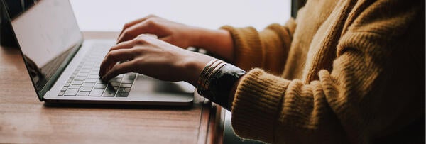 hands typing on a laptop